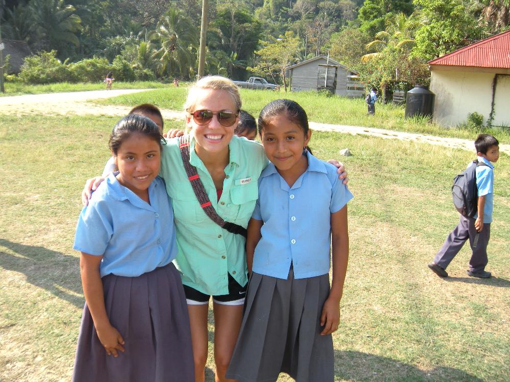 a UA student posing with two school children in Belize